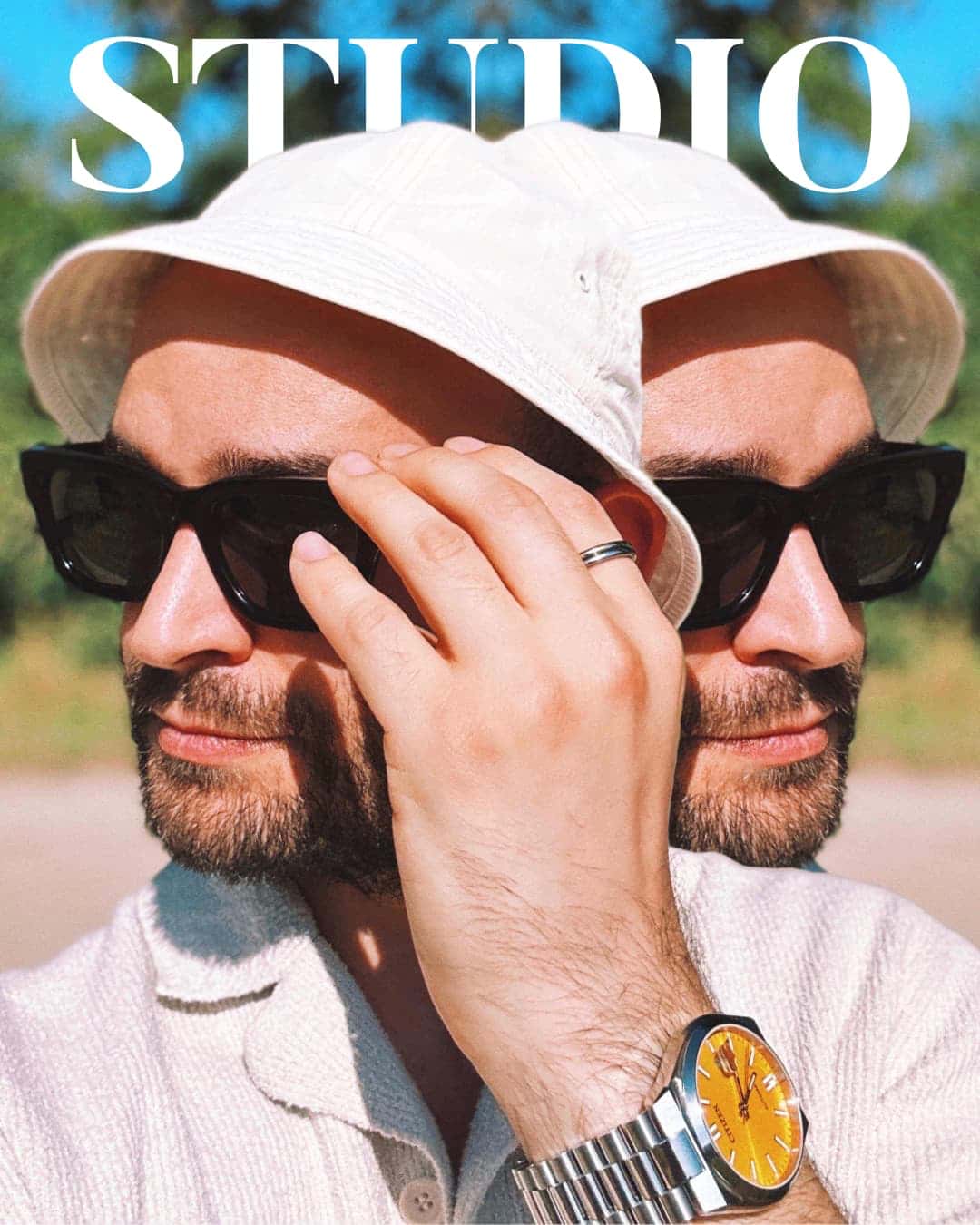 UX-Designer mit Bart trägt weißen Sonnenhut und Sonnenbrille im Sommer. Hand am Hutrand, goldene Uhr sichtbar. Text "STUDIO" im Bild.